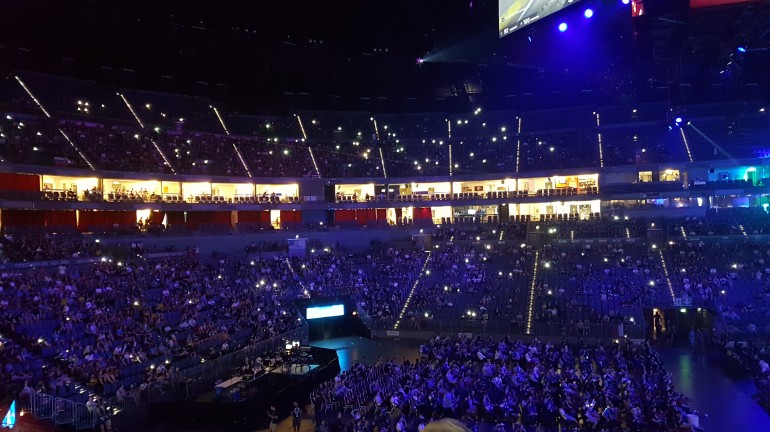 Crowd holding up their phone screens during an interval between matches or map change.