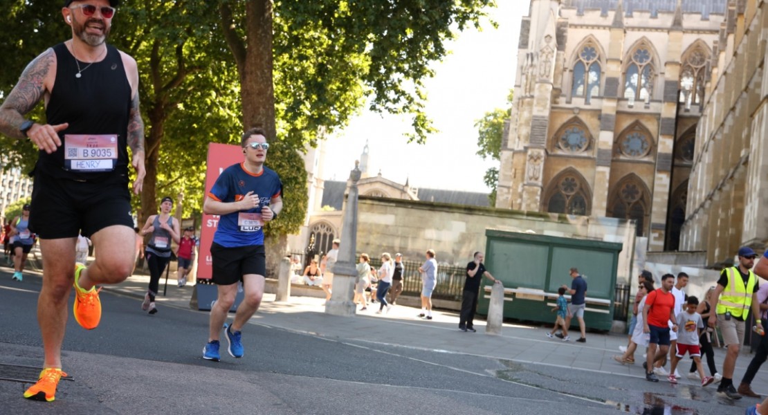 A picture of myself (Luc Shelton) running past the Palace of Westminster. There is someone to my left. I am wearing a SpecialEffect athletic jersey.